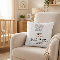 תעודת לידה מעוצבת על כרית מונחת על כורסה בחדר התינוק