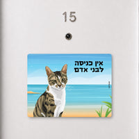 שלט לדלת עם איור חתול על רקע חוף ים וכיתוב הומוריסטי, עבודת יד של Kopi Blok