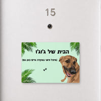 שלט לדלת עם איור כלב על רקע ירוק עם עלי דקל וכיתוב אישי, עבודת יד של Kopi Blok