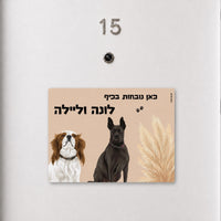 שלט לדלת עם איור שני כלבים על רקע פמפס בז' וכיתוב אישי, עבודת יד של Kopi Blok